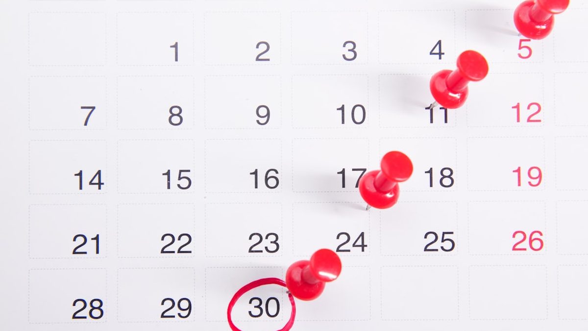 a calendar with red push buttons pinned to it