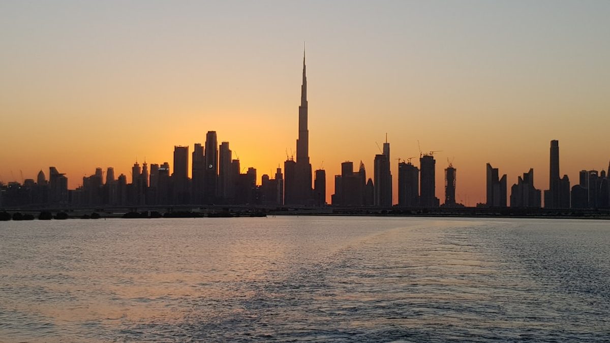 city skyline across body of water during sunset
